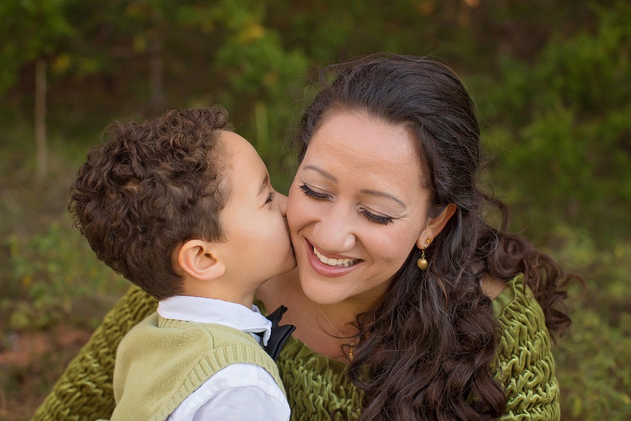 son gives his mother a kiss on the cheek